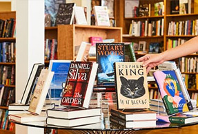 Flying Cloud Books with Lady touching books.